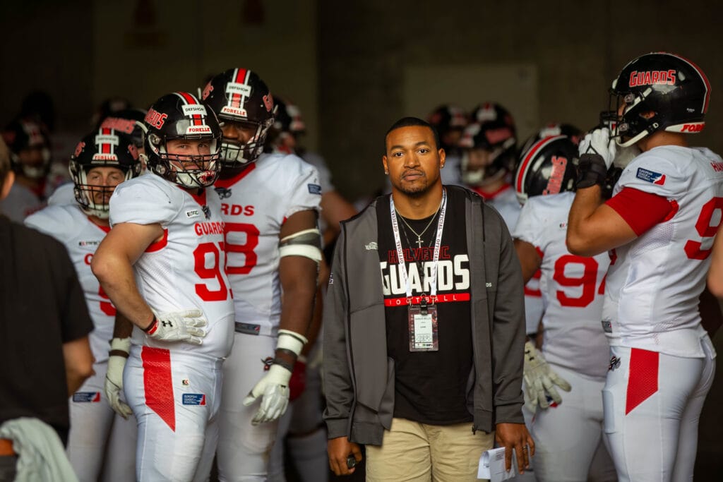 Football team with coach; ready for action with helmets