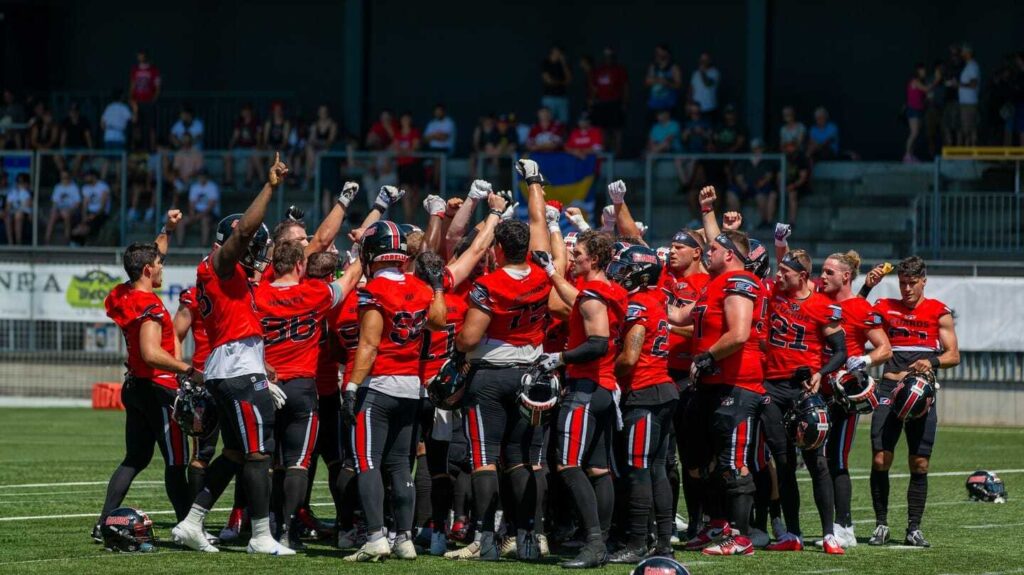 Football team celebrating with raised fists, excited and united.