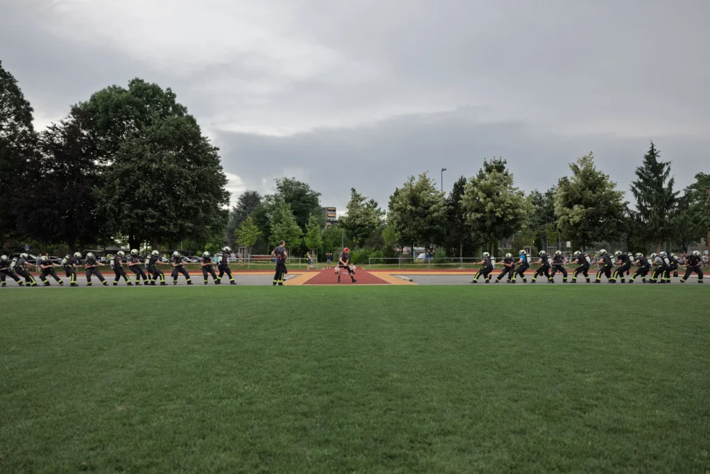 Firefighter team sprinting across a field during a firefighter combat challenge