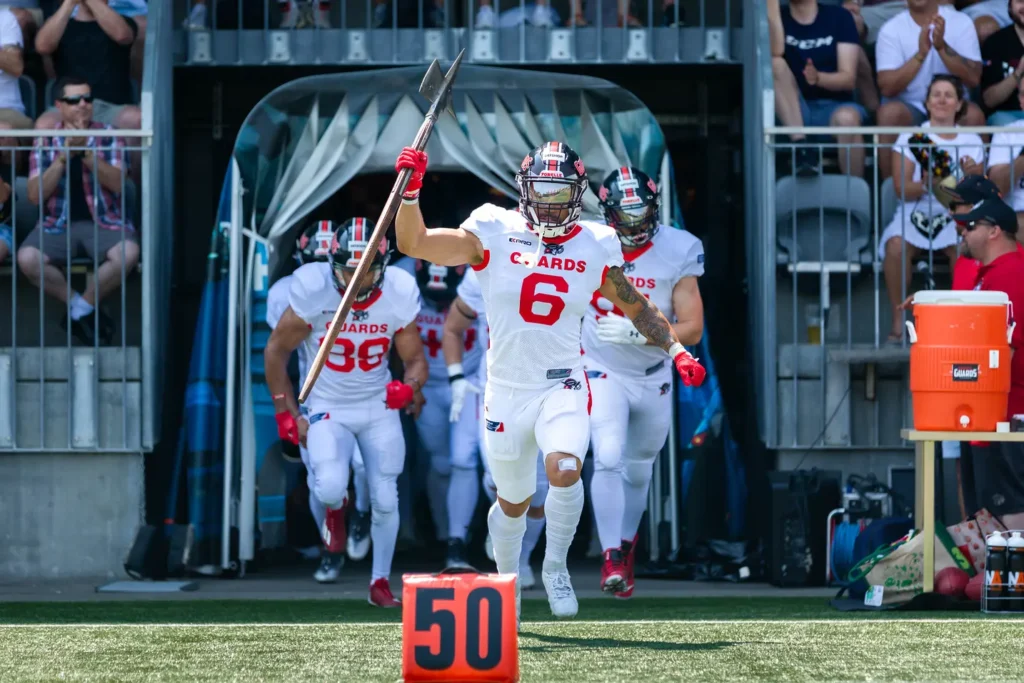 Football player leading team onto field with battle axe, ready for action.