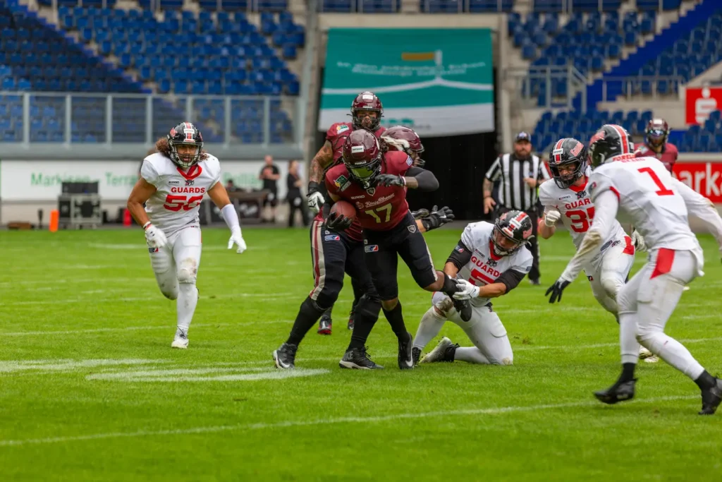 Football players in action, one player is tackled during game.