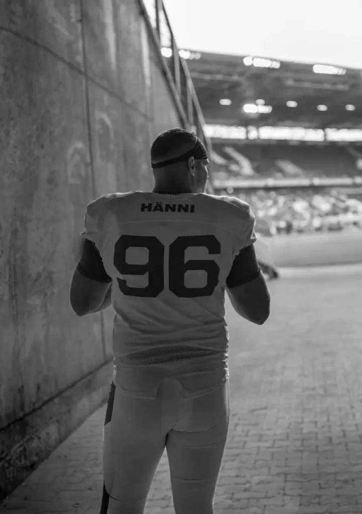 Football player wearing number 96 looks towards stadium field