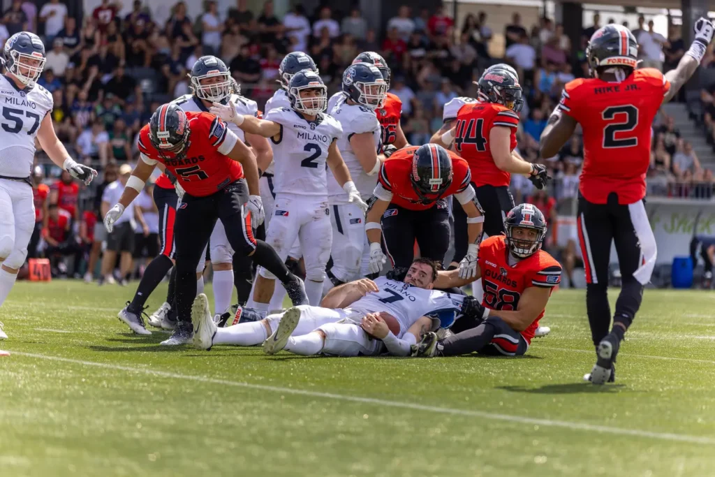 Football player sacked during Milan Guards game action on field.