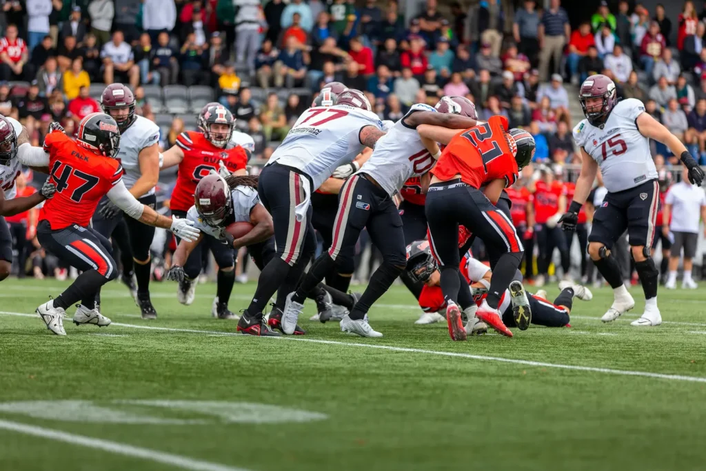 Football players collide during a game, intense focus, action shot