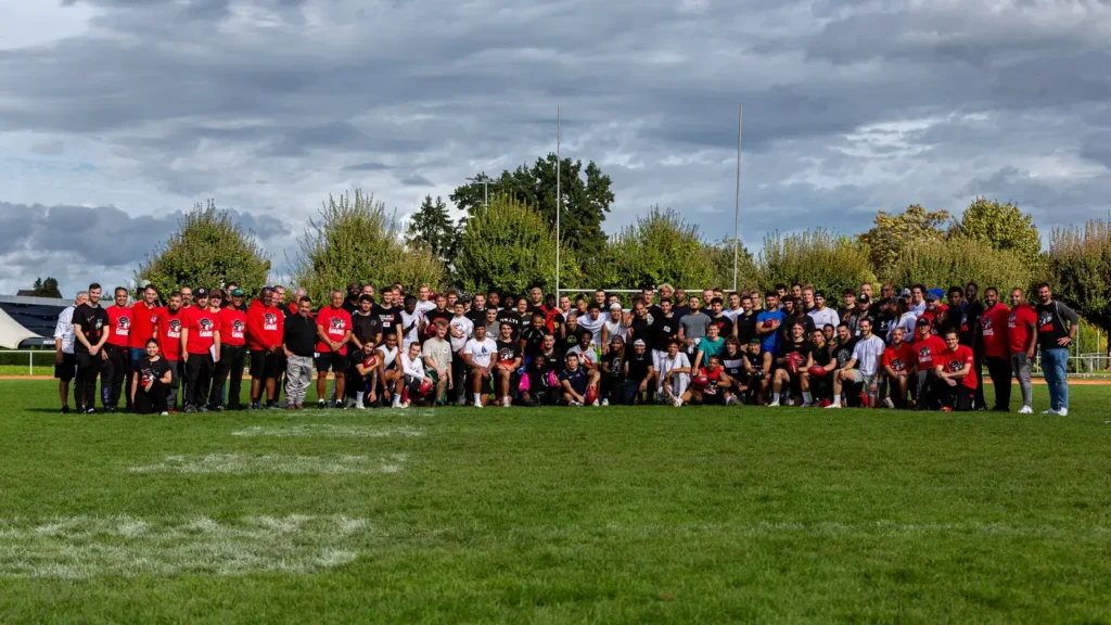 Large group of football players posing for team photo on field.
