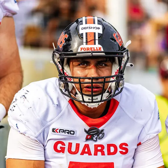 Football player in helmet, looking intense after game, ready for action.