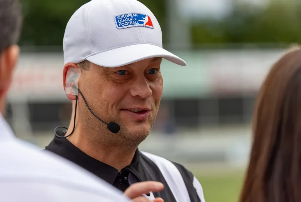 American football referee wearing a mic, on the field.
