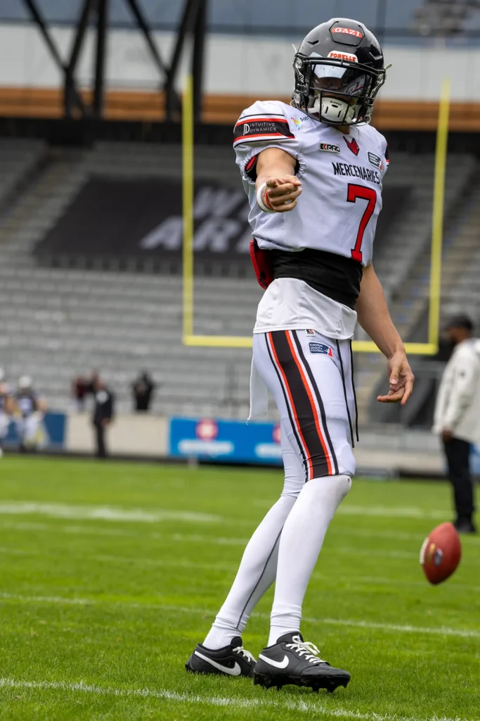 Football player in uniform poised to kick football on the field