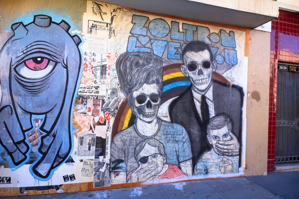 Colorful San Francisco mural featuring stylized skeleton family and collage elements.