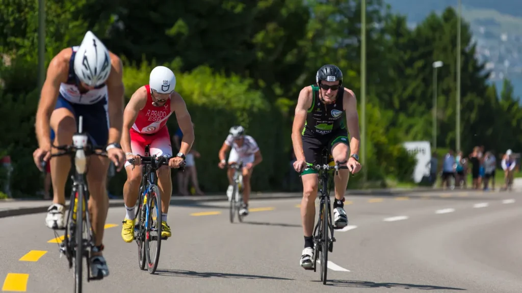 Group of triathletes riding road bikes in close formation during the cycling leg of a triathlon