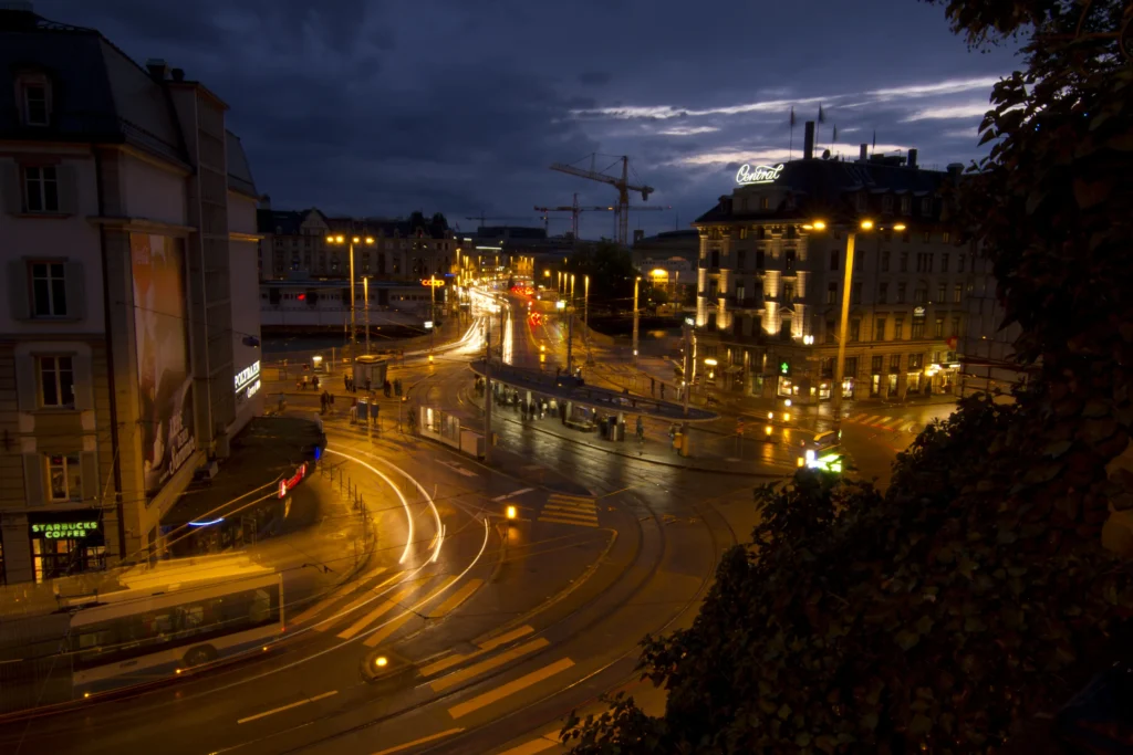 Night cityscape with traffic light trails and historic Zurich buildings.