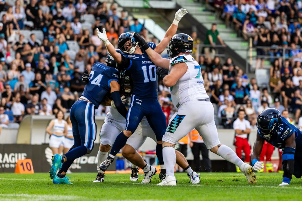 Simon Hugger (Munich Ravens, 72) blocks Luke Glenna (Nordic Storm, 10) while Mitch Fettig (Nordic Storm, 24) tackles an opponent. 29.08.2026, Innsbruck, European Football Alliance, Championship Game, Munich Ravens - Nordic Storm. Foto: PFA/Rico Doninelli