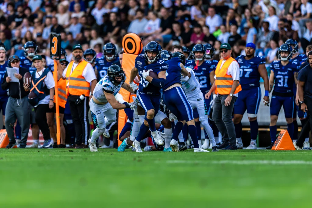 Brendan Beaulieu (Nordic Storm, 19) carries the ball while Malik Stanley (Munich Ravens, 3) attempts a tackle. 29.08.2026, Innsbruck, European Football Alliance, Championship Game, Munich Ravens - Nordic Storm. Foto: PFA/Rico Doninelli